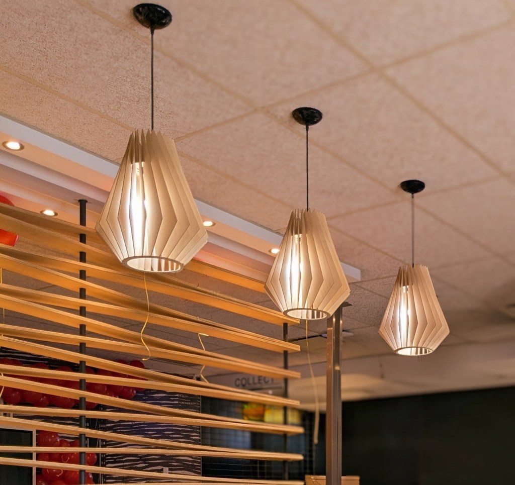 Three white pendant shaped chandeliers hanging from the ceiling