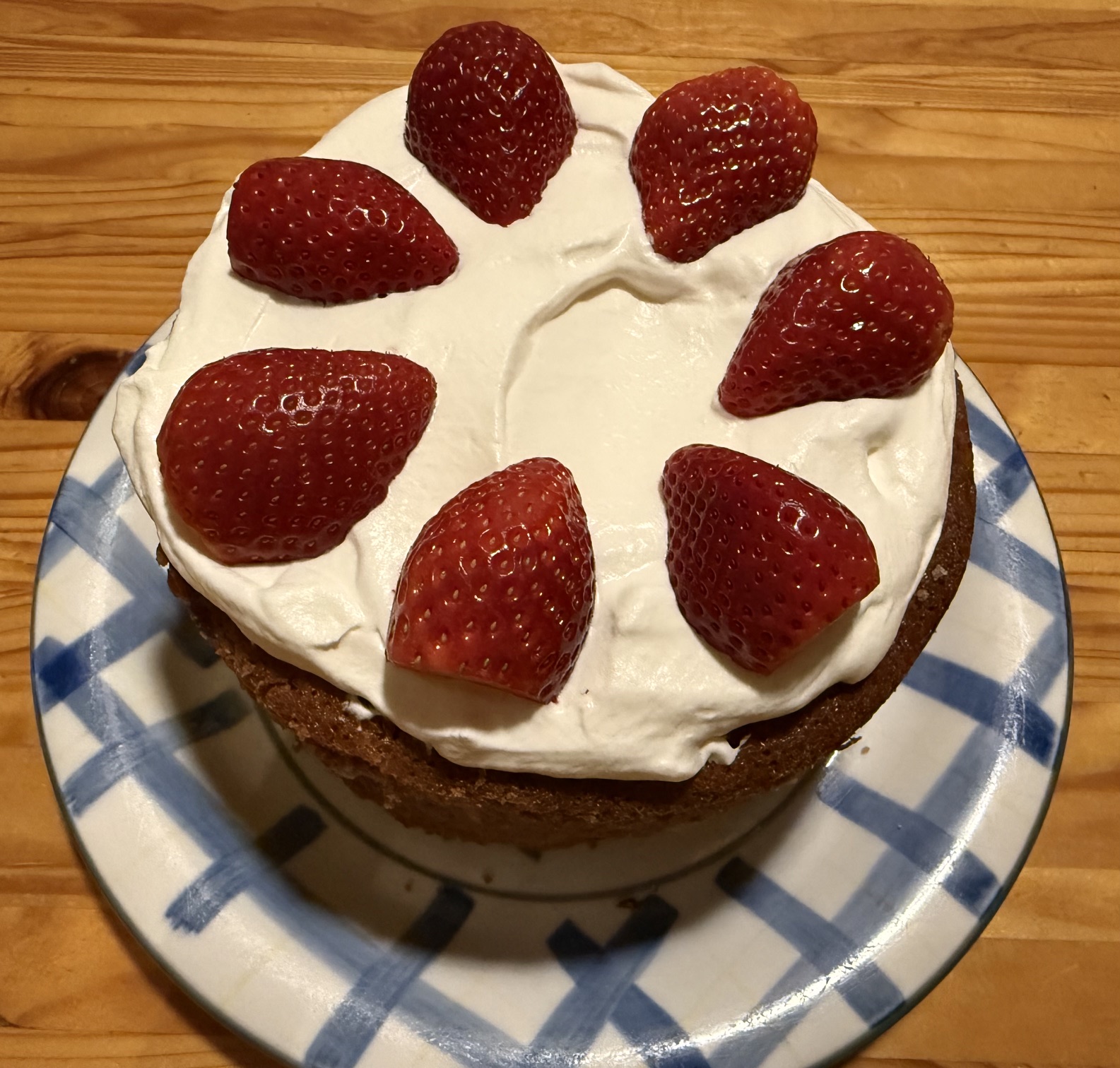 Golden strawberry cake decorated with fresh cream and fresh strawberries