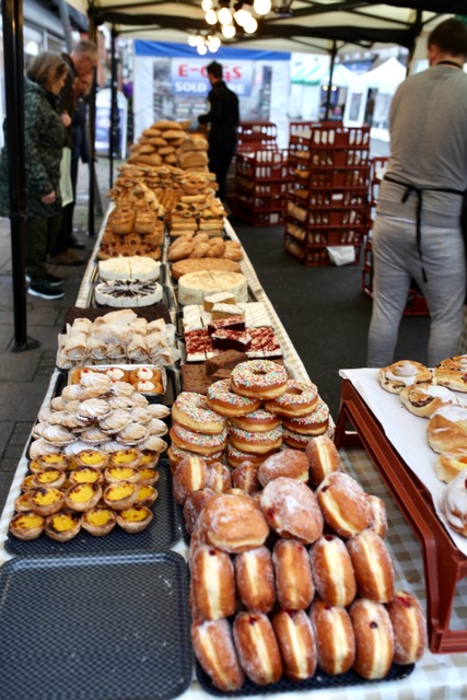 a loaded table of delicious cakes at the Charter Market.
