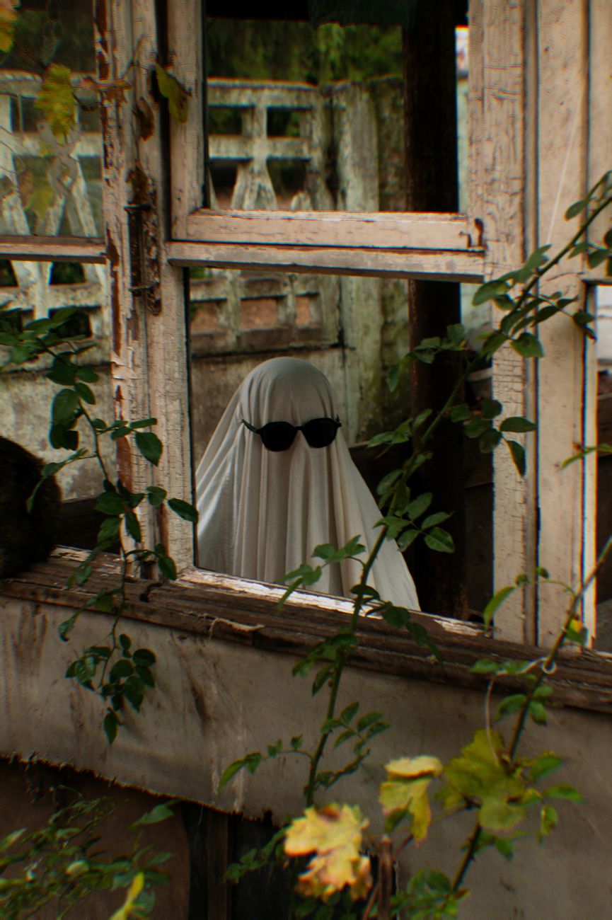man wearing ghost costume seen in a window